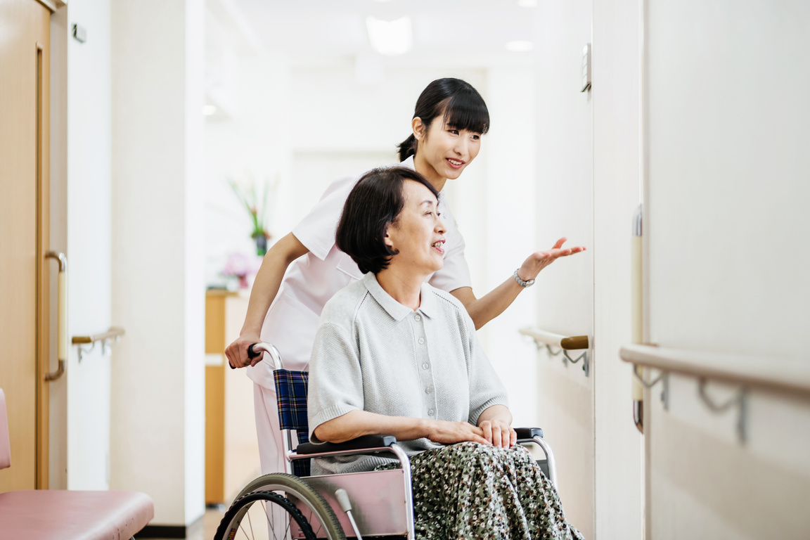 Japanese Nurse Talking To Elderly Patient